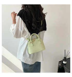 Detailed view of light green seashell bag with rhombus pattern on a model