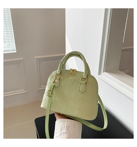 Detail of mint green shell handbag featuring classic quilted texture and gold hardware