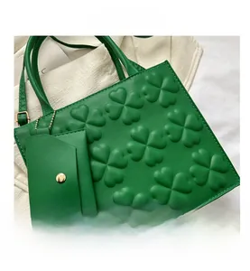 Detail of green PU leather tote bag with embossed clover pattern and small matching pouch