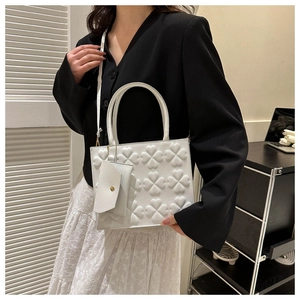 Detail of white PU leather crossbody bag with 3D clover embossing and mini wallet