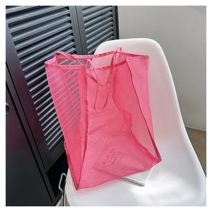 Detalle del bolso tote de malla rosa que muestra la textura transpirable en silla