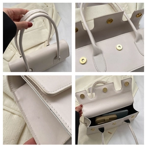 Detail view of cream PU leather handbag showing golden hardware and magnetic buckle