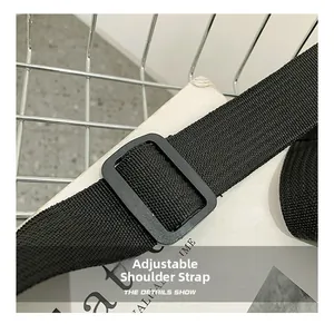 Close-up of adjustable woven shoulder strap with black plastic buckle for messenger bag