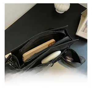 Interior view of black PU crossbody bag with double compartments and small coin purse charm