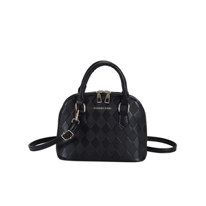 Classic black quilted shell handbag with golden hardware and adjustable strap on white background