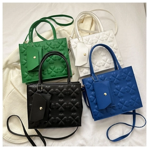 Detail of four retro clover-embossed handbags in green, white, black and blue with coin purses