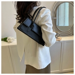 Elegant black leather underarm bag shown on model for a stylish commute appearance