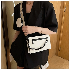 Detail view of a white rectangular crossbody bag with a mini pouch and black acrylic chain