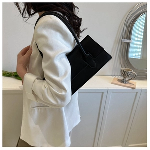Chic black rectangular underarm bag styled with a white blazer for a minimalist office look