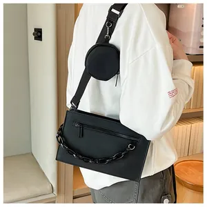 Détail de la sacoche noire street style avec chaîne épaisse et petite pochette ronde