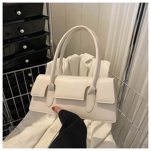Detail view of a cream white rectangular underarm bag with unique flap closure