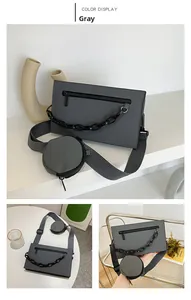 Gray crossbody bag featuring front zipper pocket and detachable round coin purse detail