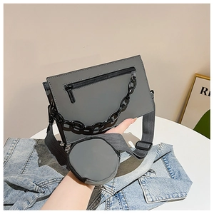 Détail du sac bandoulière gris foncé avec chaîne noire et petit porte-monnaie rond