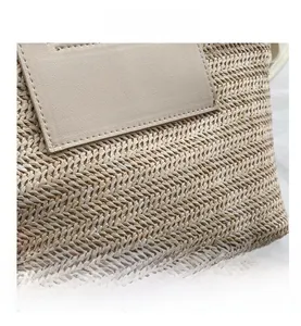 Détail du tissage en paille naturelle et de l'empiècement en cuir sur le sac seau