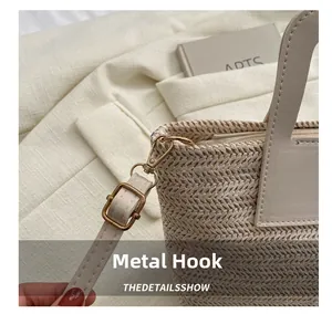 Détail du crochet en métal doré clair et de la bandoulière en cuir beige du sac seau