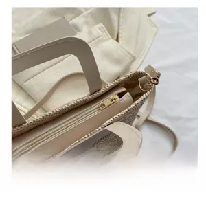 Détail de la fermeture éclair dorée lisse sur le sac cabas en paille tressée