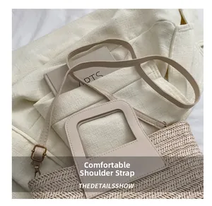 Gros plan du sac seau en paille tissée avec bandoulière réglable sur un blazer beige