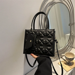 Minimalist black square handbag with clover embossed pattern and small accessory pouch
