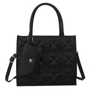 Black PU leather tote bag with clover embossing and detachable strap in a front view
