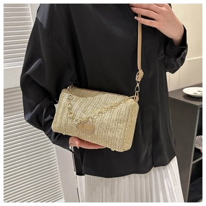 Détail du sac à bandoulière en paille beige avec chaîne dorée et finitions en cuir