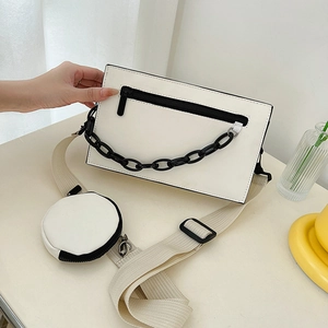 Minimalist white PU leather crossbody bag with black chain detail and small round pouch