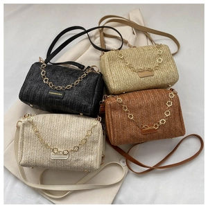 Gros plan de sacs bandoulière tissés en quatre couleurs avec chaînes dorées fleurie