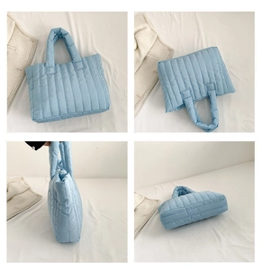 Detail view of light blue quilted tote showing vertical stitching and padded handles