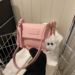 Rosa gesteppte Umhängetasche mit Klappe und Plüschanhänger in einer Shopping-Szene