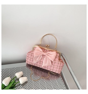 Détail de la texture en tweed rose avec nœud élégant et poignée dorée ronde