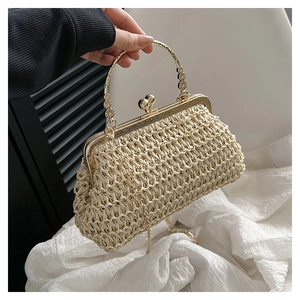 Dettaglio della borsa in paglia intrecciata con cornice in metallo dorato e chiusura