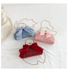 Gros plan de trois sacs en tweed avec de grands nœuds en satin et chaînes dorées