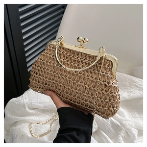 Dettaglio pochette retrò in paglia intrecciata con cornice dorata e chiusura a sfera