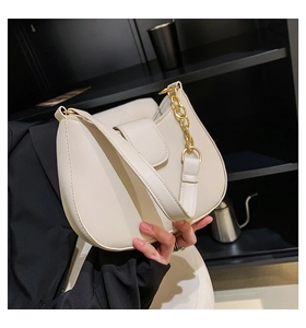 Détail du sac selle blanc en cuir avec chaîne dorée et fermeture à rabat magnétique