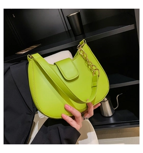 Détail d'un sac hobo en cuir vert vif avec une bandoulière à grosse chaîne dorée chic