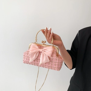 Sac à main en tweed rose avec grand nœud en satin et bandoulière chaîne dorée