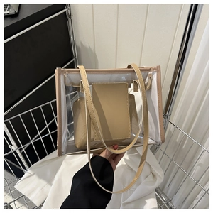 Detail of transparent PVC tote bag with removable beige leather inner pouch and handles