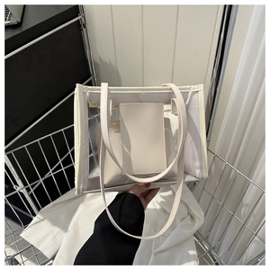 Detail of transparent PVC tote bag with cream leather trim and inner pouch for summer