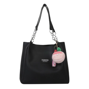 Black leather tote bag with metal chain strap and cute pink peach plush charm