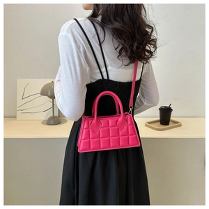 Détail d'un petit sac à main rose matelassé avec poignée ronde et bandoulière amovible