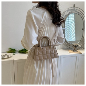 Détails du motif matelassé beige et de la bandoulière réglable sur le sac à main