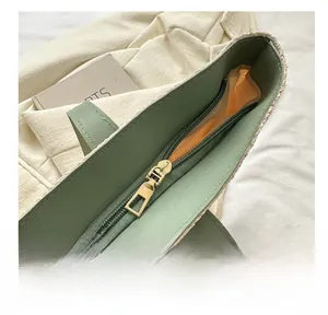 Détail du sac fourre-tout vert avec fermeture éclair dorée et doublure en tissu orange