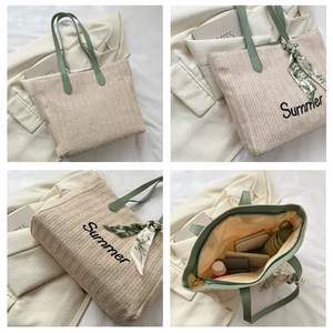 Détail du cabas en paille avec broderie Summer et poignées en cuir vert