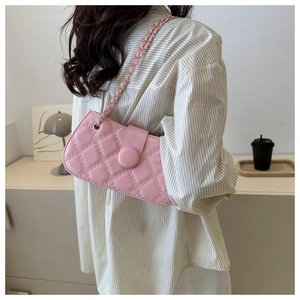 Rosa gesteppte Ketten-Umhängetasche an einem Model in einem stilvoll minimalistischen Raum