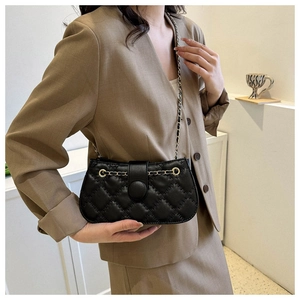 Detail einer schwarzen gesteppten Ledertasche mit rundem Verschluss zum schicken Outfit