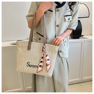 Détail du cabas en paille avec broderie Summer, anses en PU marron et foulard en soie