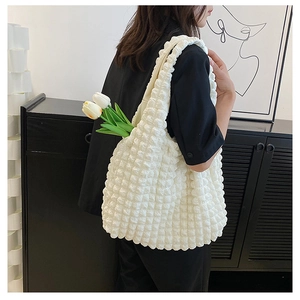 Detailed macro view of the white popcorn textured fabric on a minimalist shoulder bag
