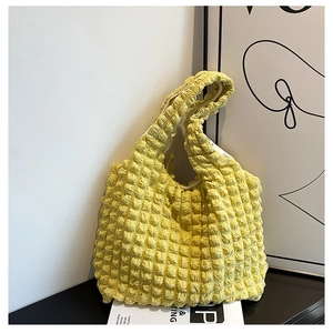 Detailed view of the bright yellow popcorn texture fabric on this stylish shoulder bag