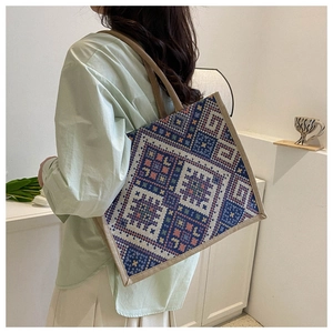 Detail of canvas tote bag showing ethnic geometric woven patterns and sturdy beige handles