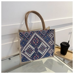 Detail of ethnic geometric woven pattern and natural hemp rope handles on tote bag