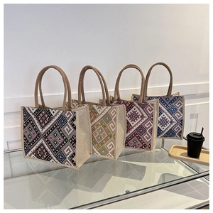 Detail view of four ethnic style canvas tote bags with geometric diamond patterns and handles
